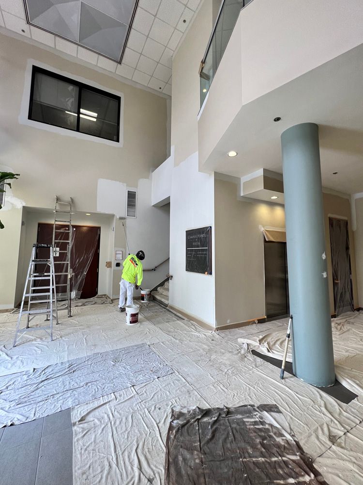 A man is standing in a large room with a ladder.