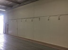 An empty warehouse with a row of hooks on the wall.