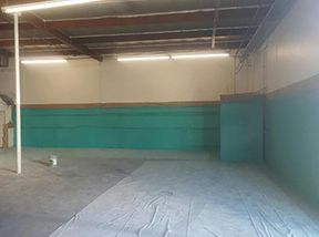 A large empty room with green walls and a white floor.