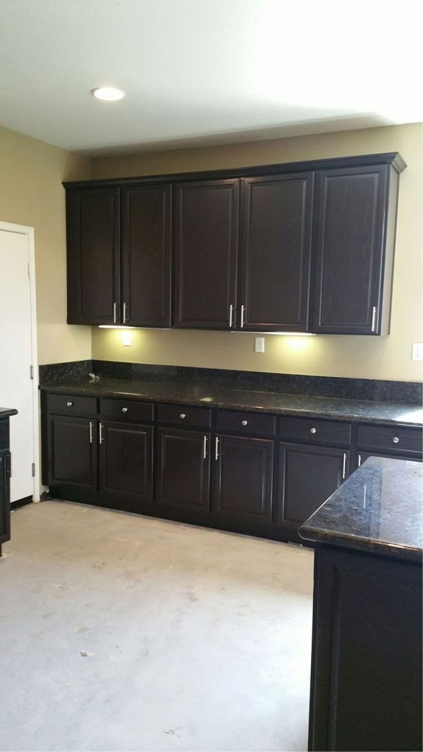 A kitchen with black cabinets and granite counter tops