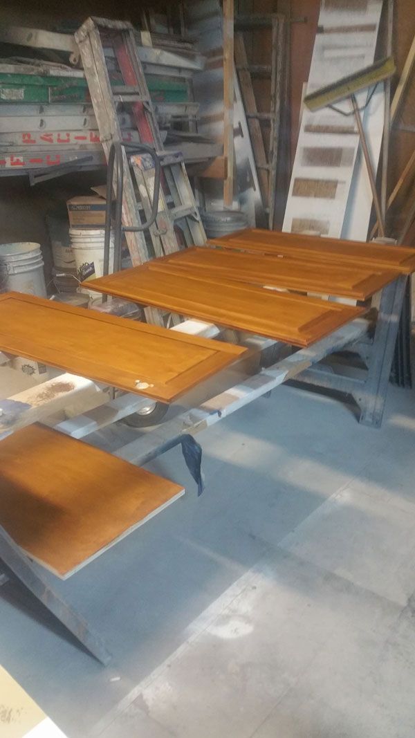 A wooden table is sitting in a garage next to a ladder.