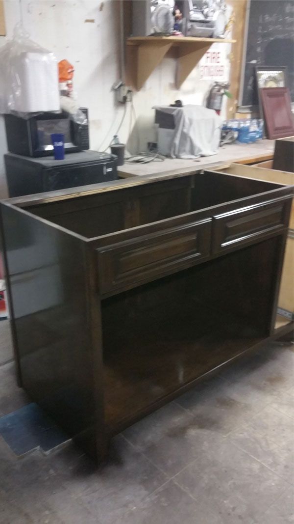 A black cabinet is sitting in a room next to a counter.