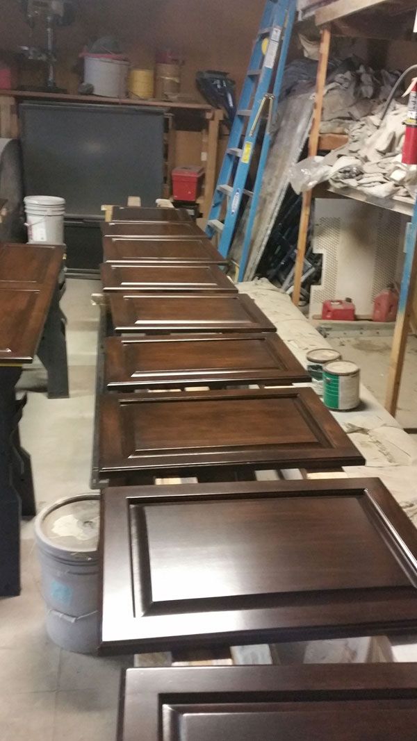 A row of wooden cabinet doors sitting on top of each other in a room.