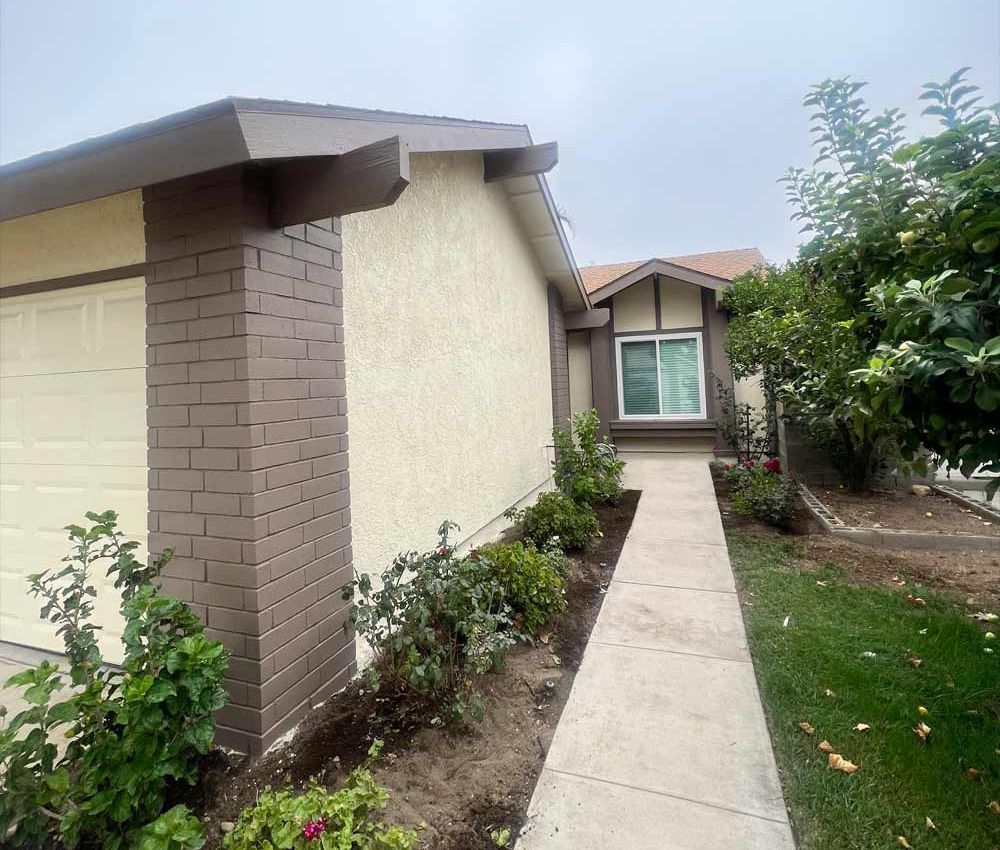 A wooden garage door is being painted black