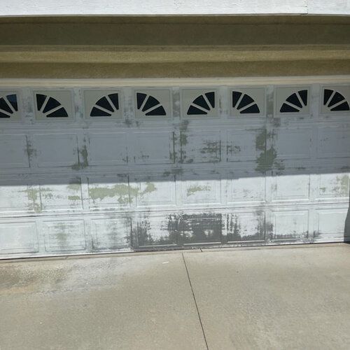 A white garage door with black triangles on it.