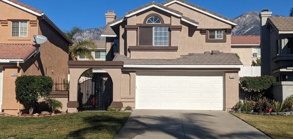 A house with a white garage door and mountains in the background.