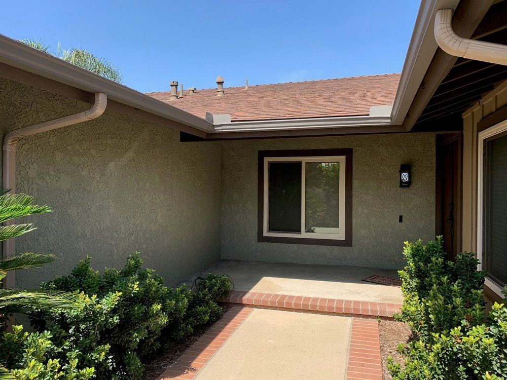 A house with a sliding glass door and a walkway leading to it.