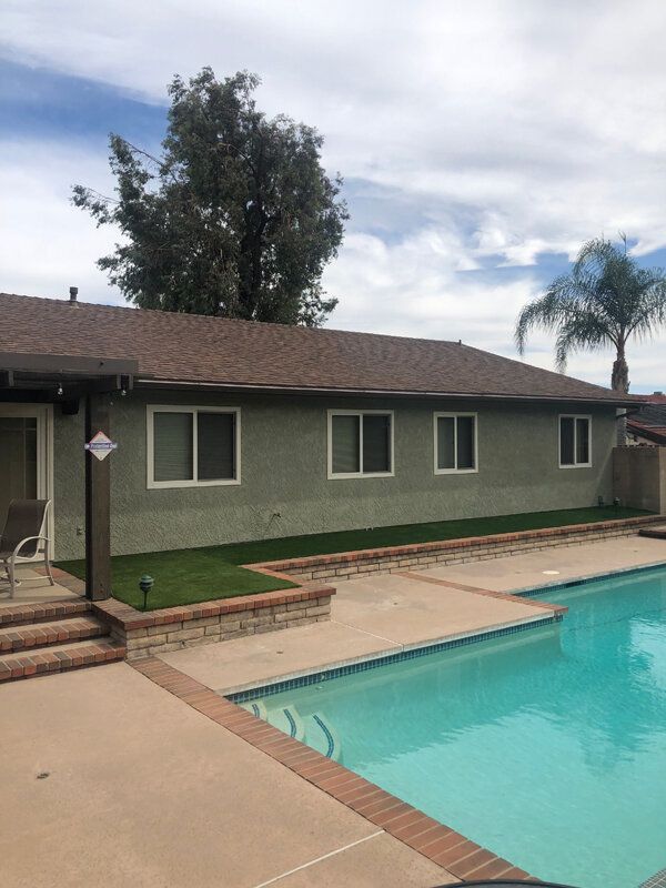 A house with a swimming pool in front of it.