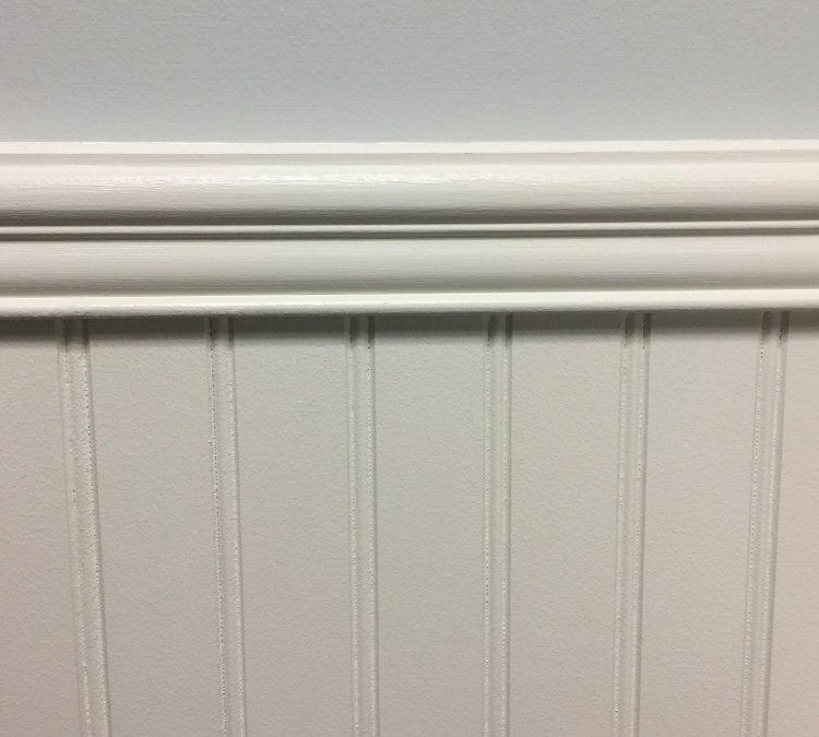 A close up of a white wall with a white molding.