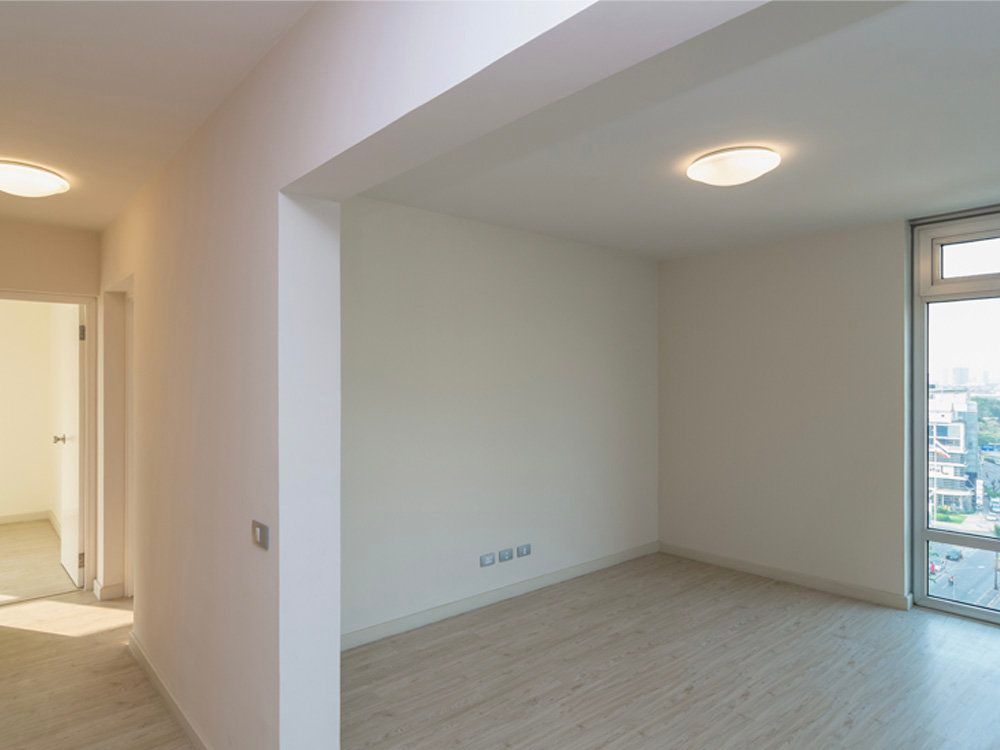 An empty room with white walls and a large window.