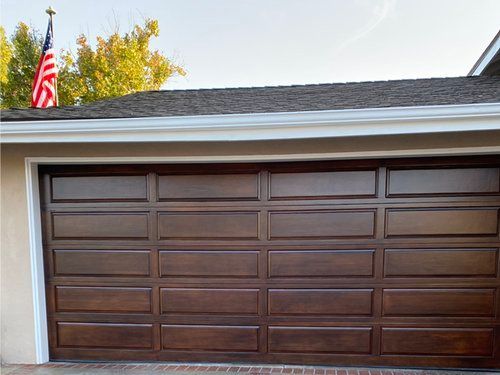 A wooden garage door with an American flag on top of it.