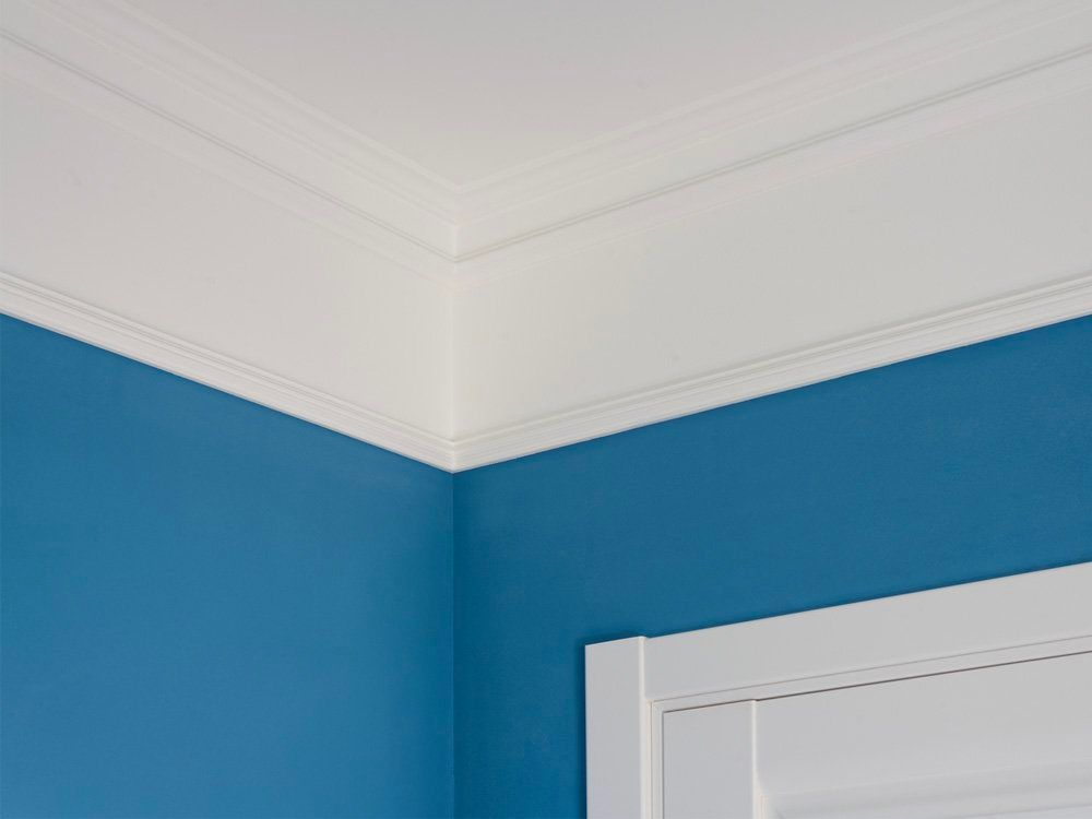 A corner of a room with blue walls and white trim.