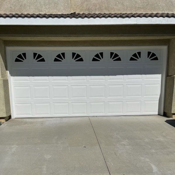 A white garage door with black triangles on it.