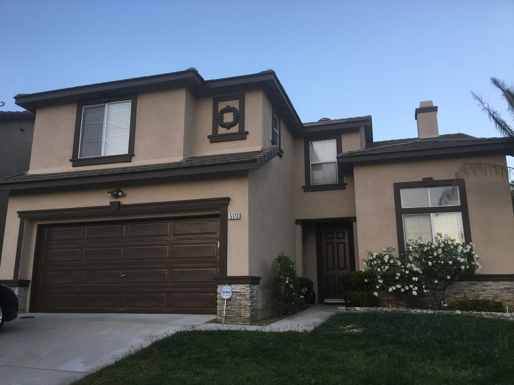 The front of a house with a brown garage door.