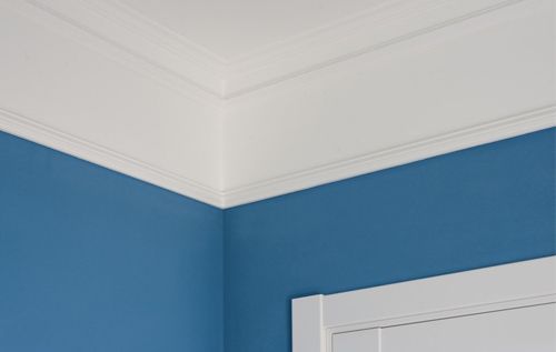 A corner of a room with blue walls and white trim.