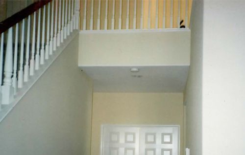 A staircase with a railing and a door in a house.