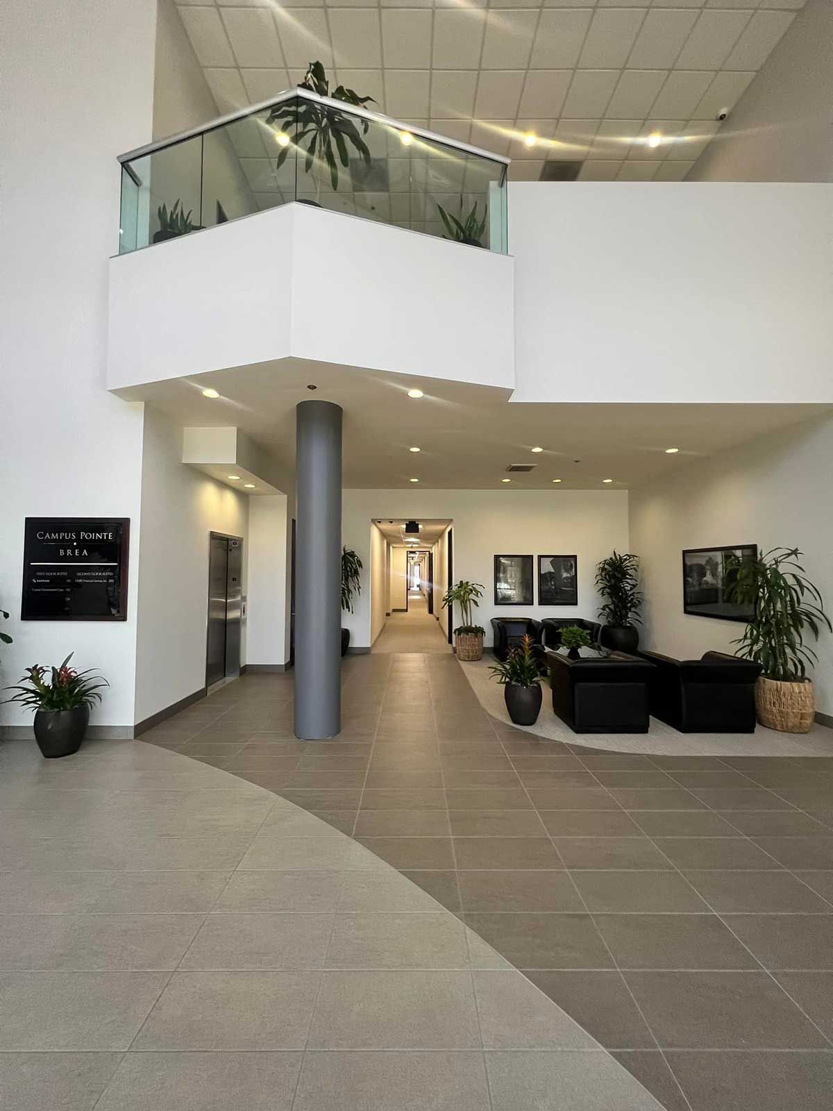 A hallway in a building with a balcony and plants