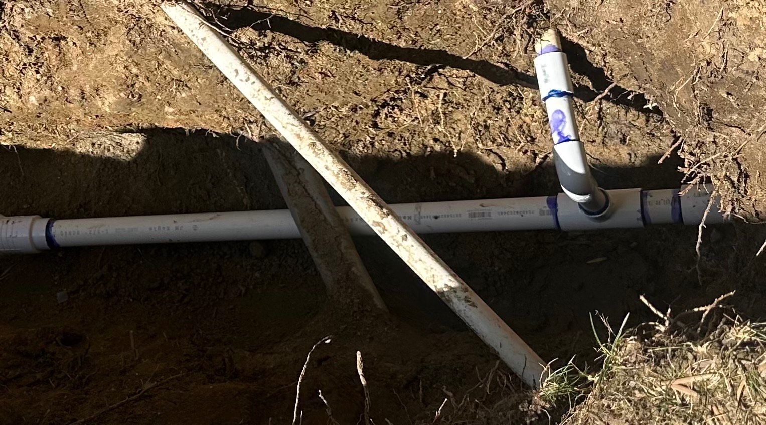 Excavated main water line repair in Encinitas, CA showing exposed pipe and trench during service