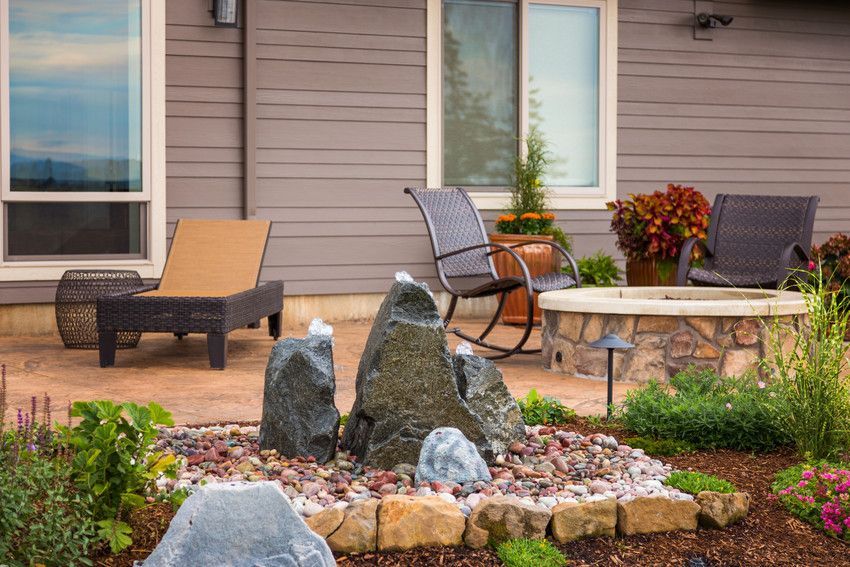 A rocking chair is sitting on a patio in front of a house.