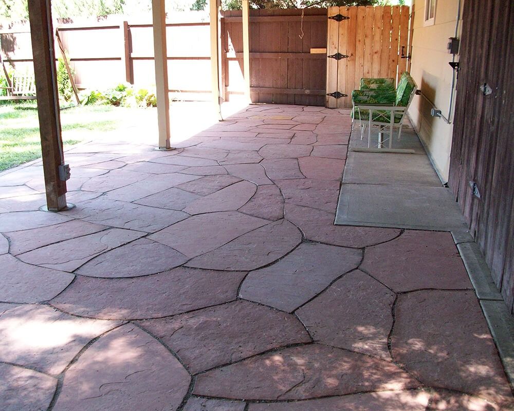 A stone patio with a wooden fence in the background