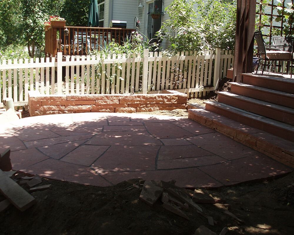A patio with stairs and a white picket fence