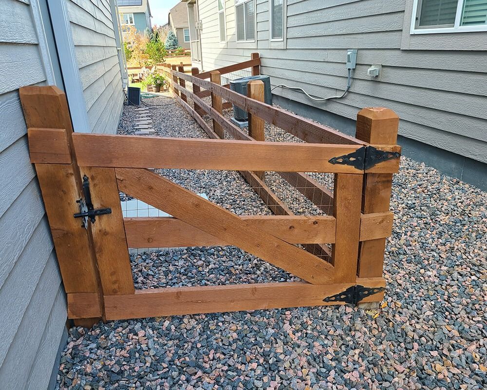 A wooden gate is sitting in front of a house.