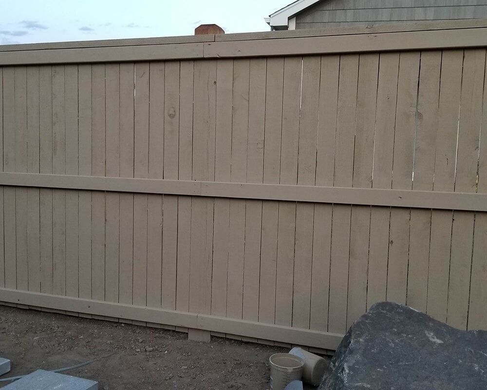 A wooden fence with a house in the background