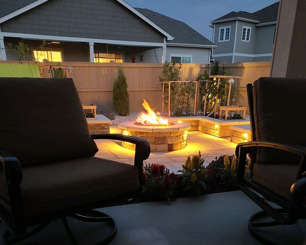 Two chairs are sitting in front of a fire pit