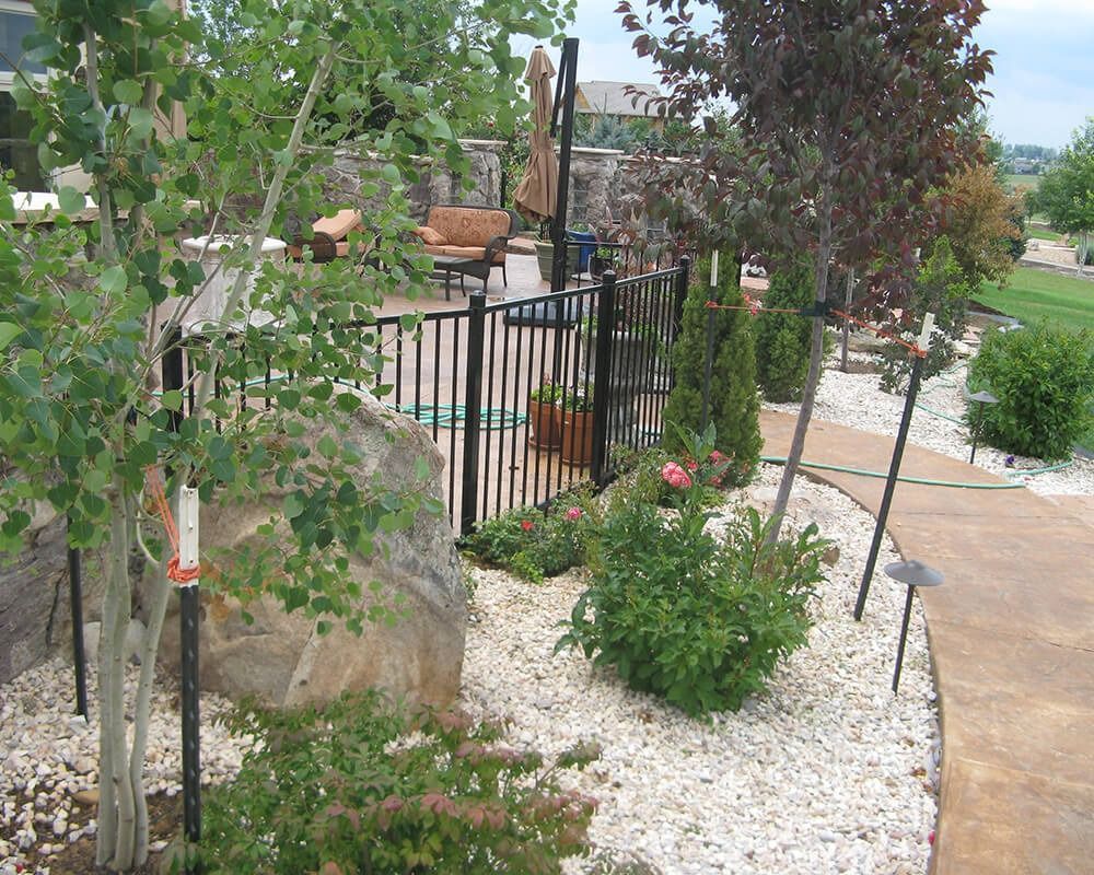 A fenced in area with trees and rocks surrounding it