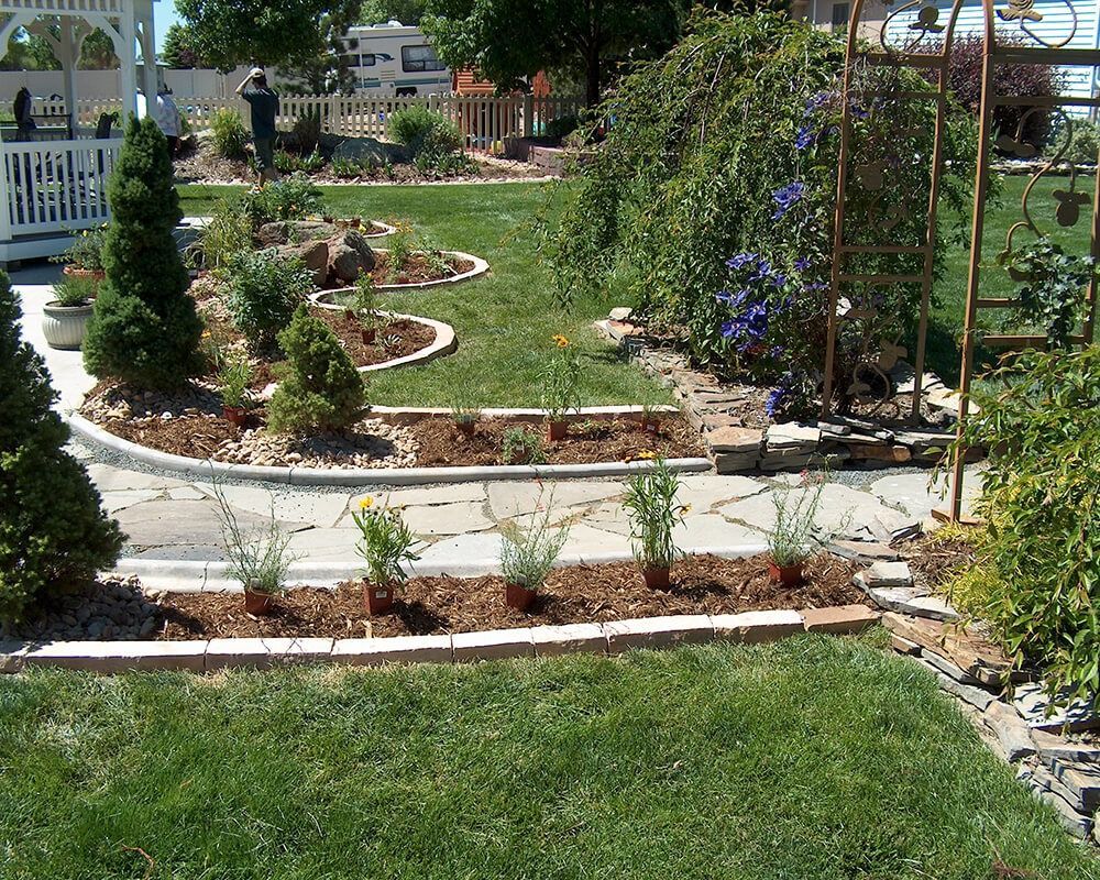 A lush green garden with a gazebo in the background