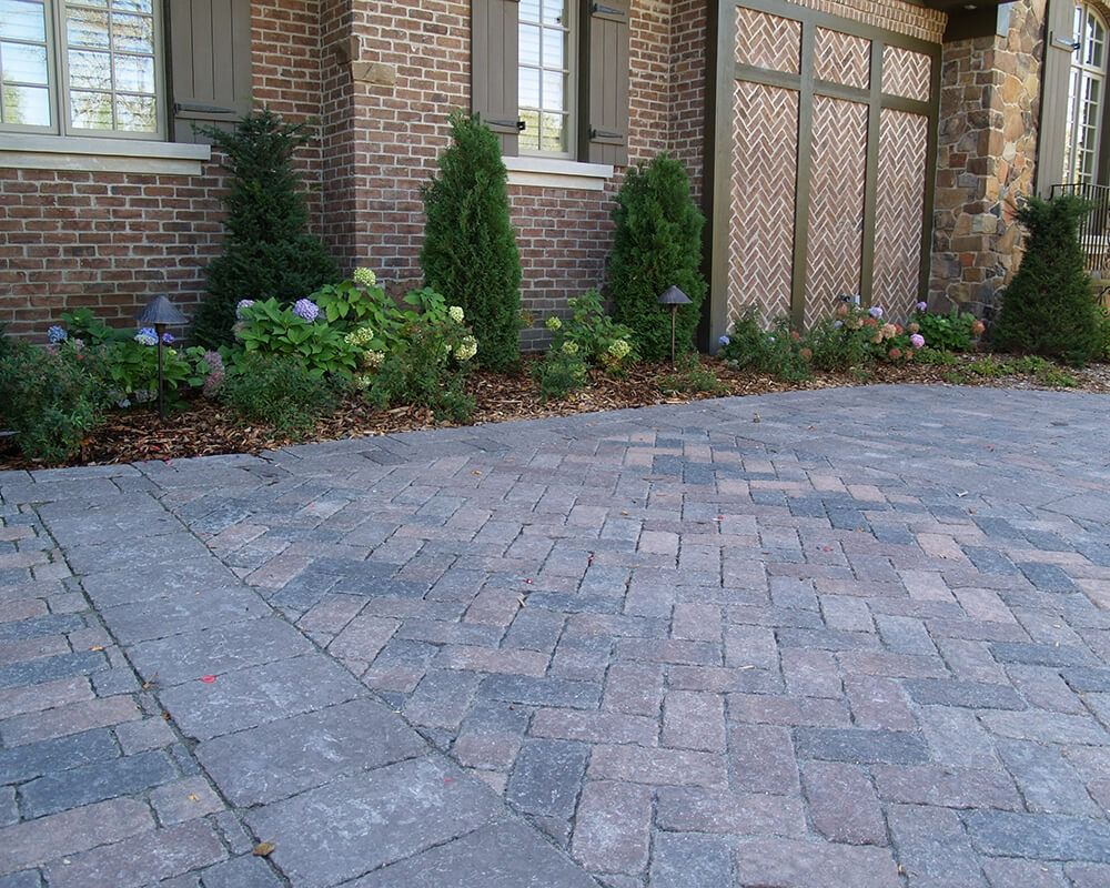 A brick house with a brick driveway in front of it
