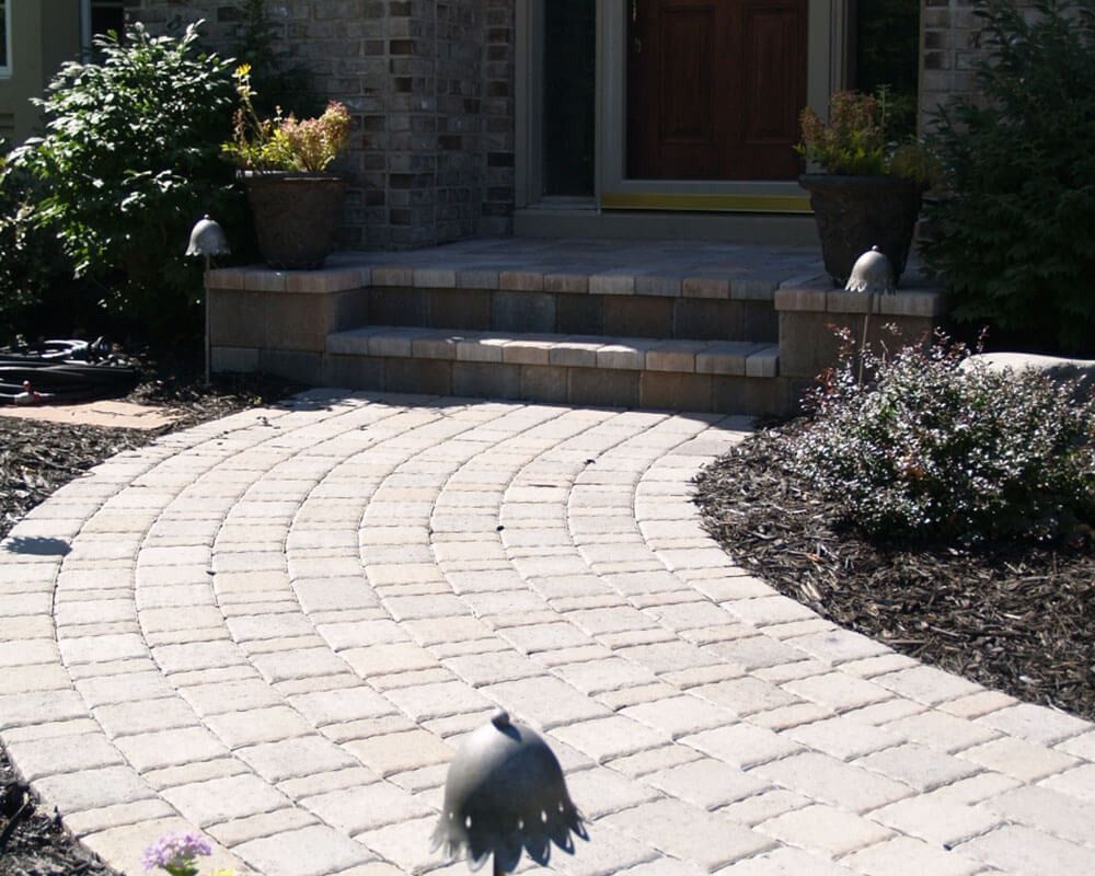 A brick walkway leading to the front door of a house