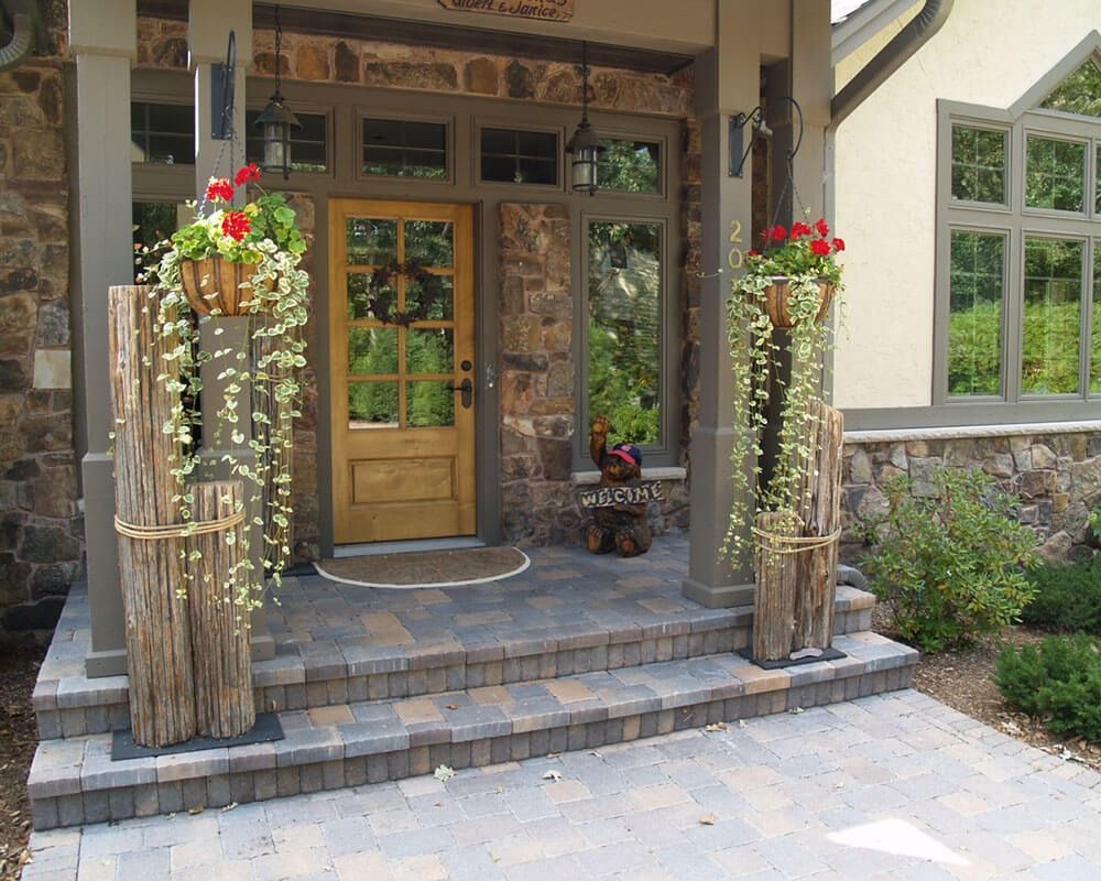 A front porch of a house with a wooden door