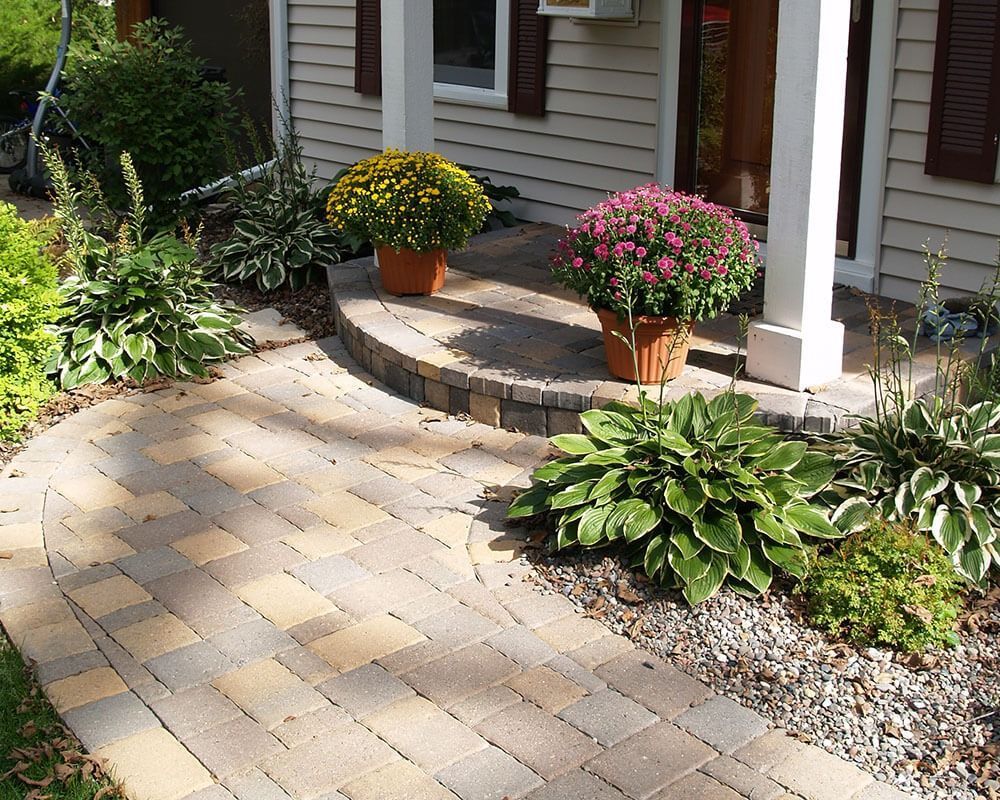 A brick walkway leading to the front door of a house