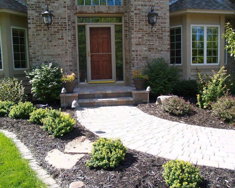 A brick house with a walkway leading to the front door