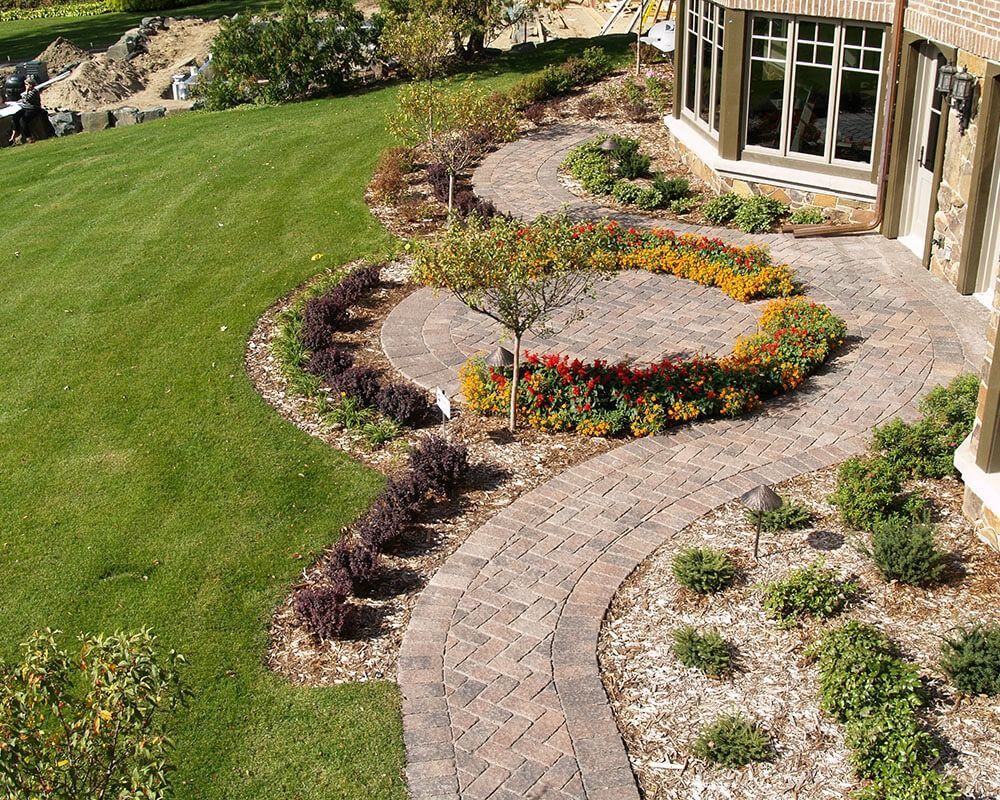 An aerial view of a brick walkway leading to a house