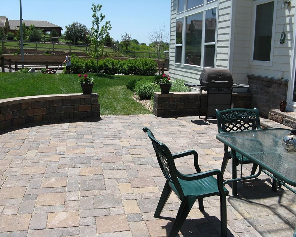 A patio with a table and chairs in front of a house