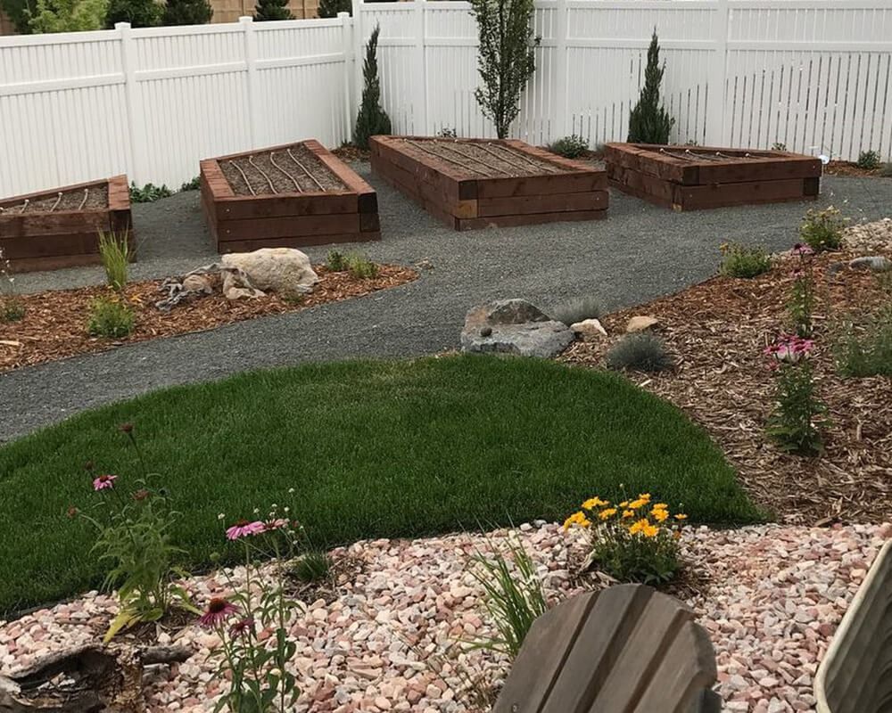 A garden with a white fence and wooden beds