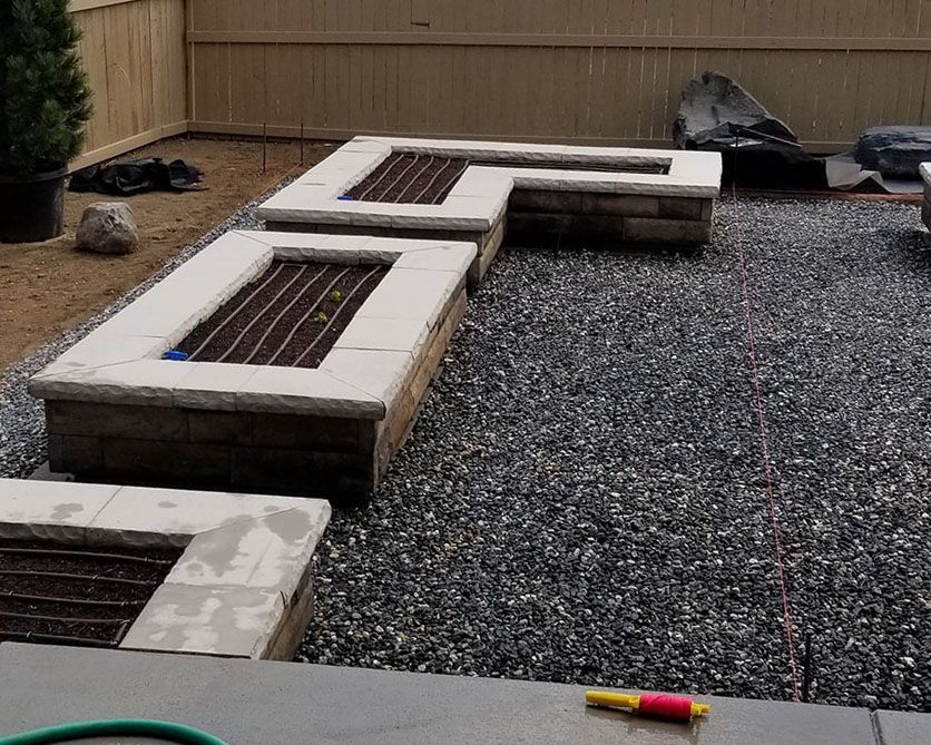 A hose is laying on the ground next to a fire pit