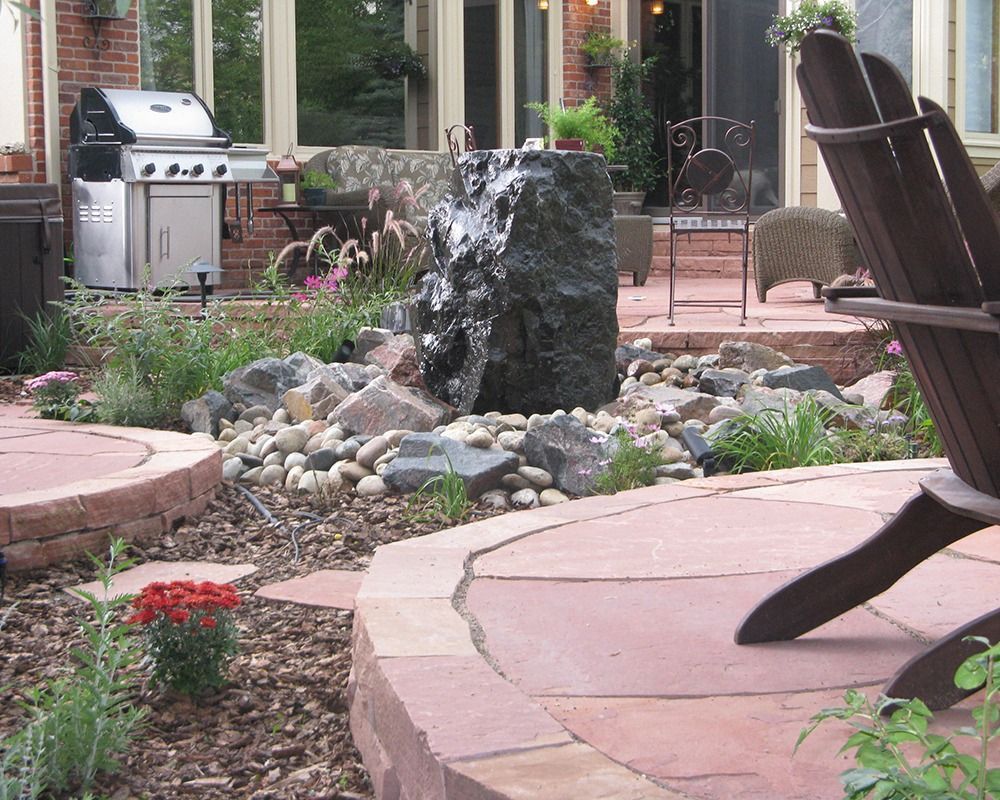 A patio with a chair and a fountain in the middle