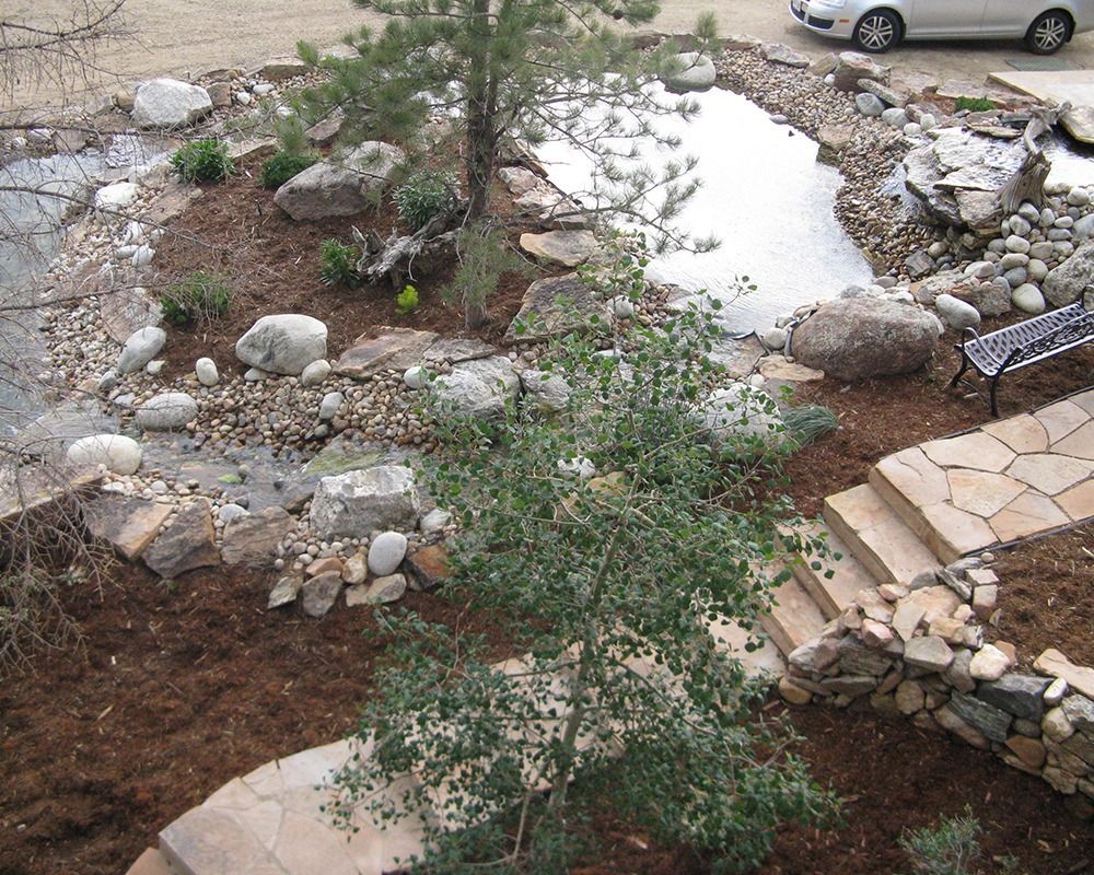 A white car is parked in a driveway next to a stone walkway