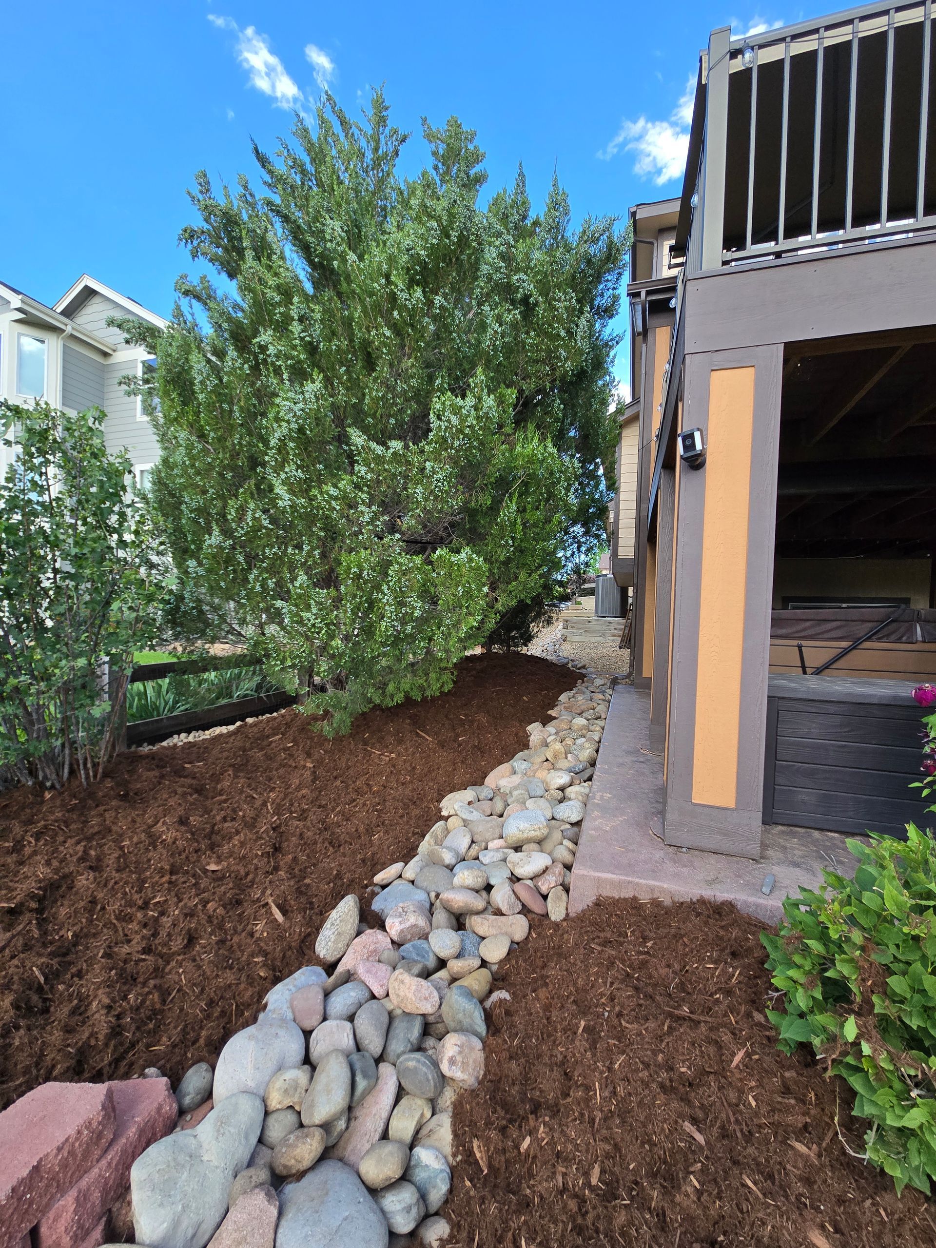 A stone path leading to a house with a tree in the background