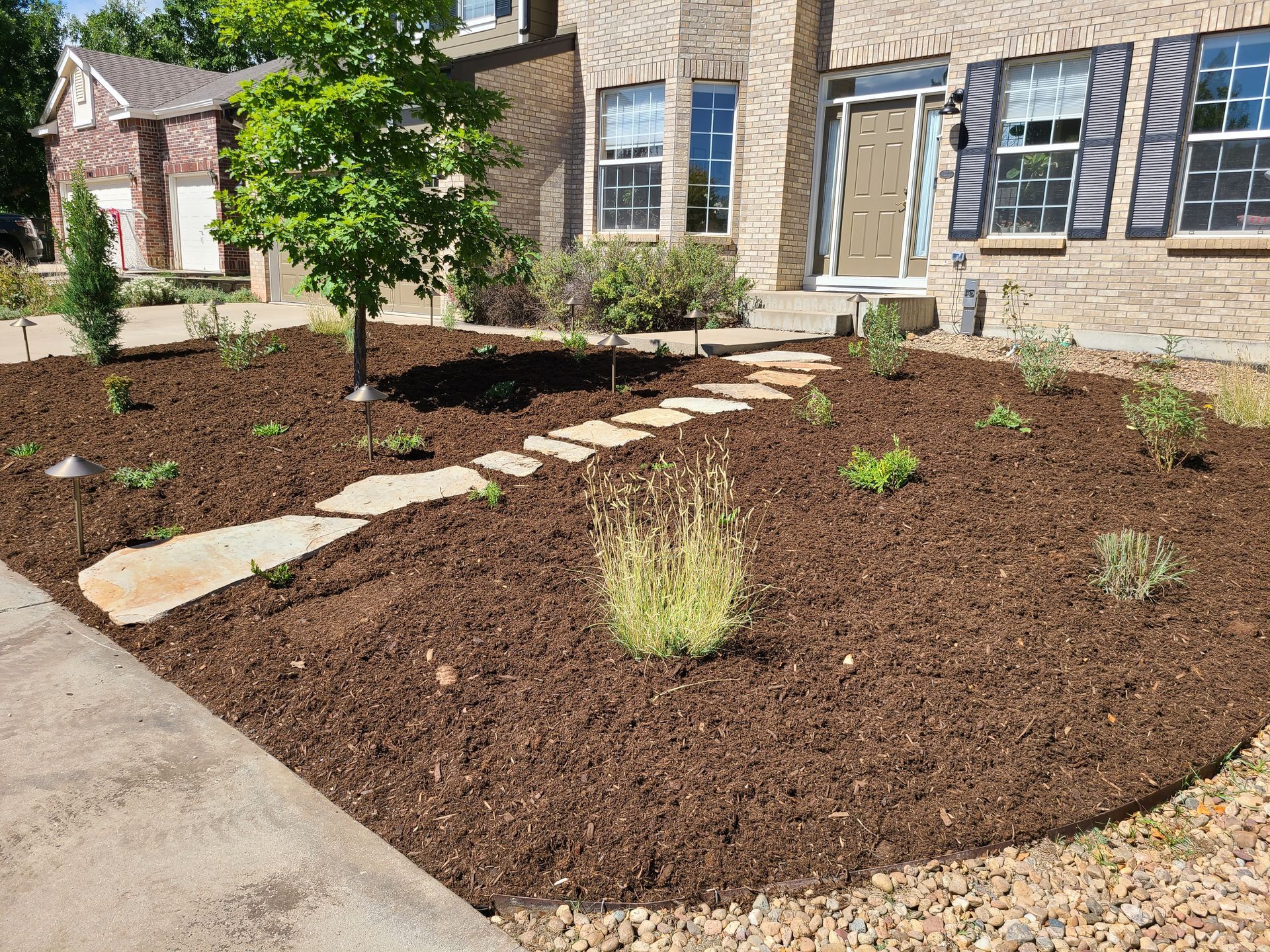 A brick house with a lush green lawn in front of it