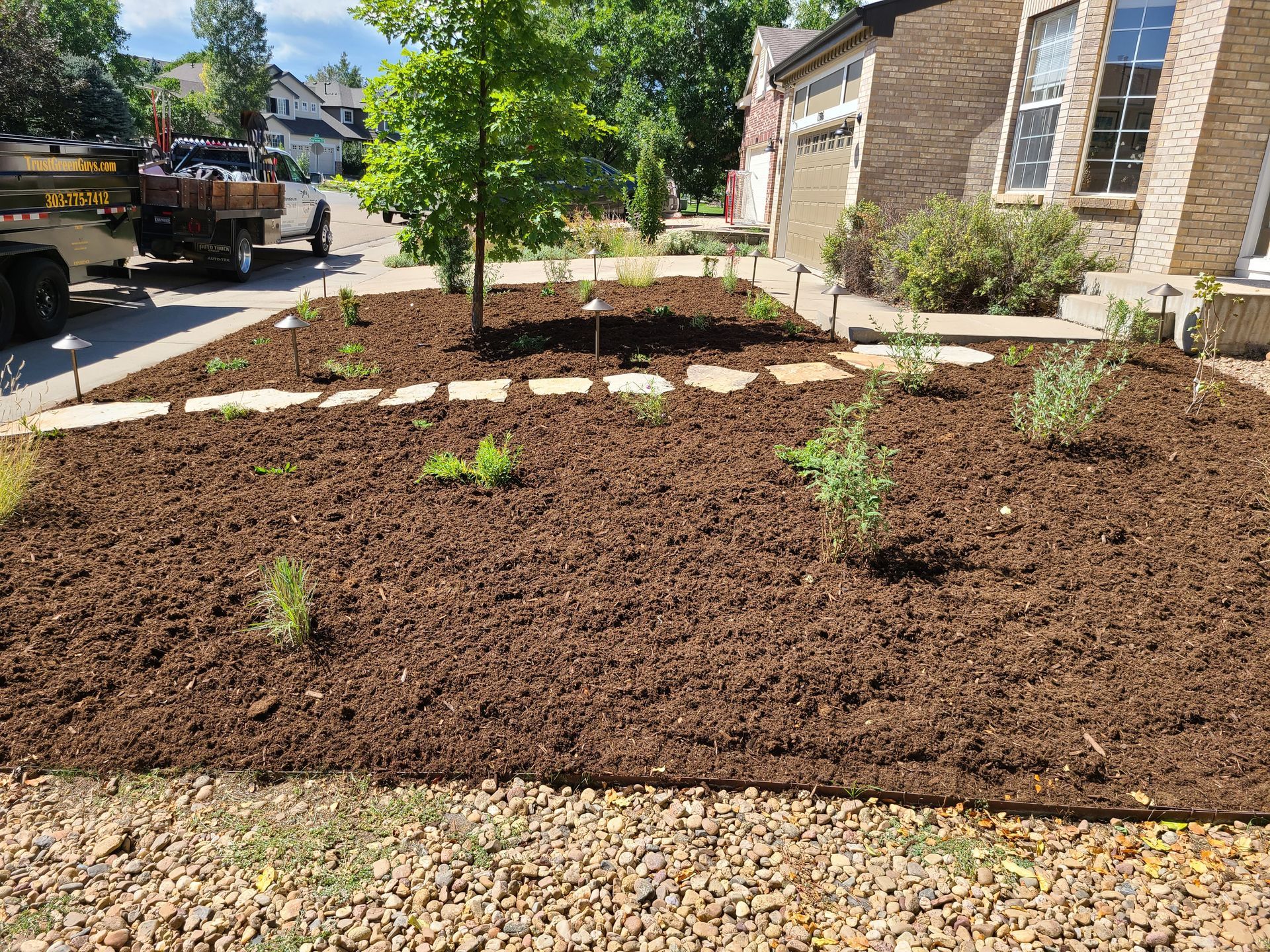 A large pile of mulch is sitting in front of a house