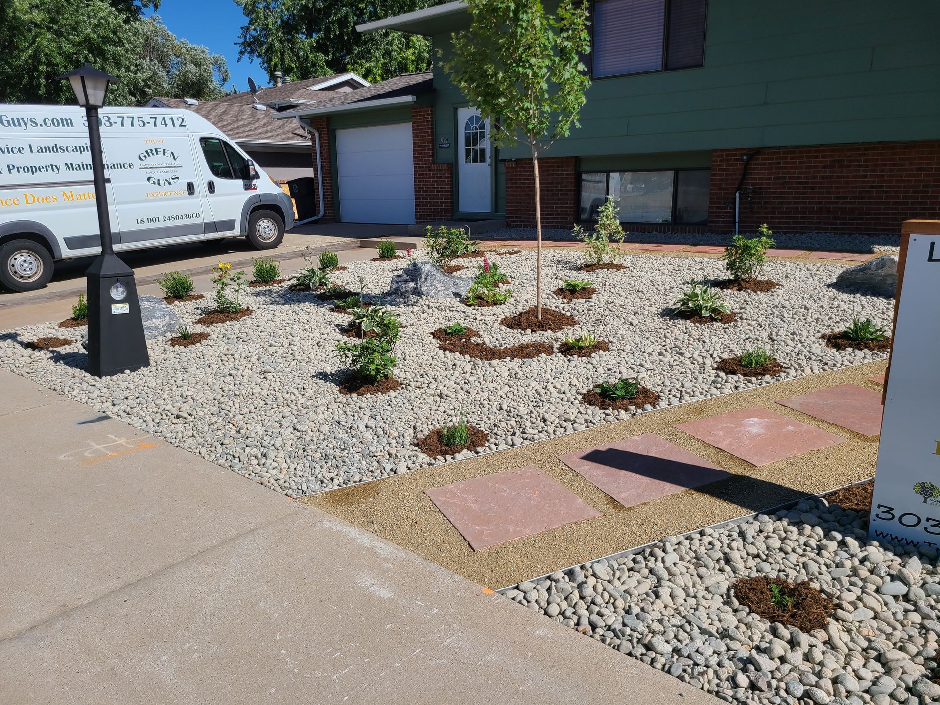A fence is surrounded by gravel and a tree