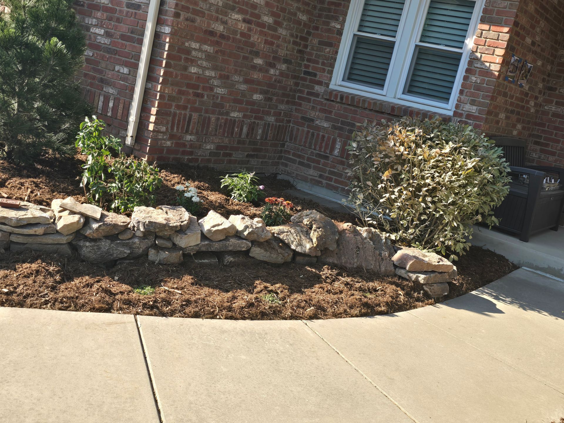 A brick house with a stone wall in front of it
