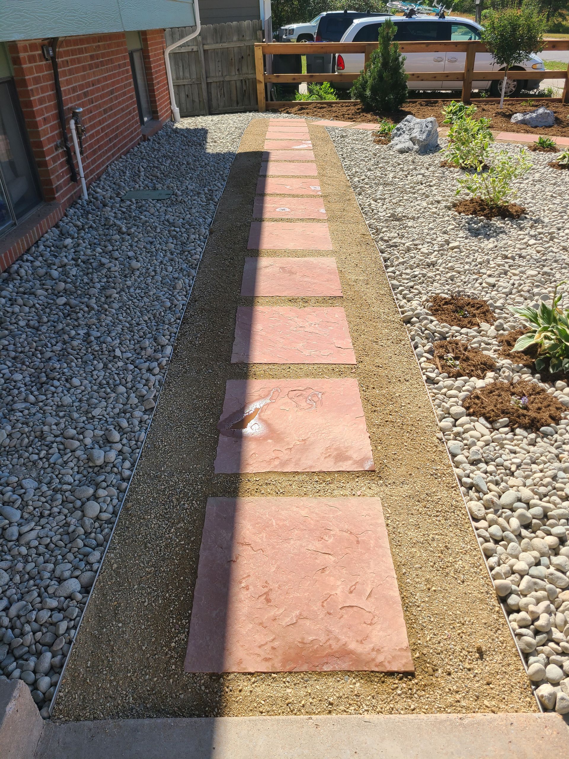 A stone walkway leading to a house surrounded by rocks