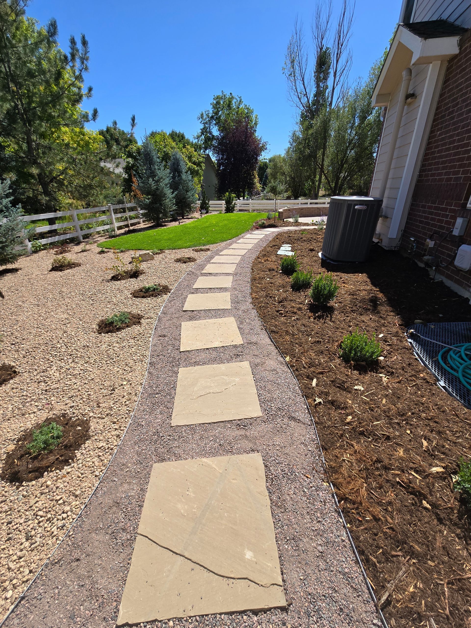 A stone walkway leading to a house on a sunny day