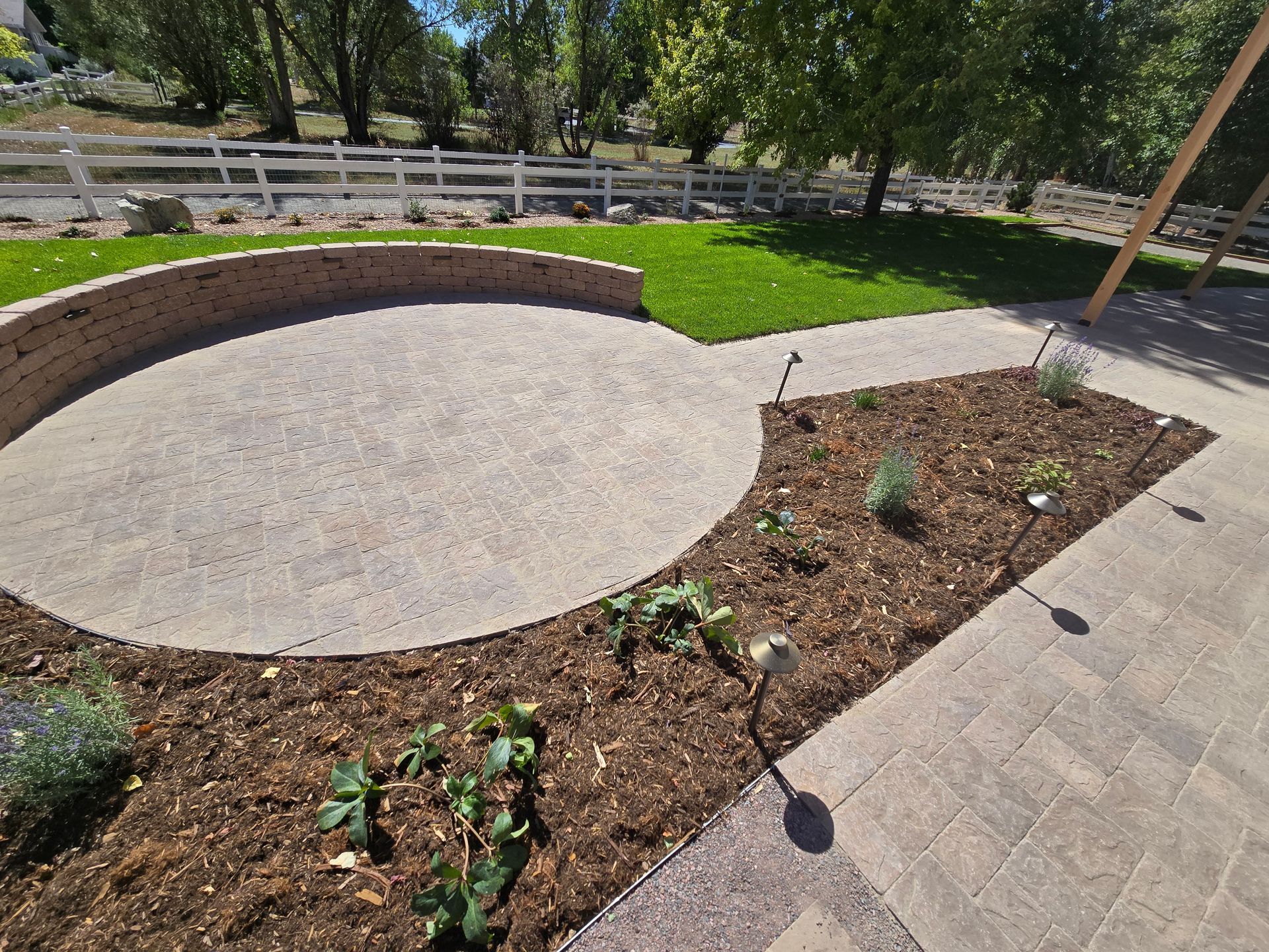 A patio with a circle in the middle of it and a fence in the background