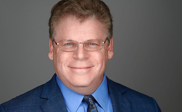 A woman is writing on a piece of paper next to a statue of justice.